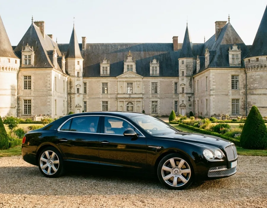 Berline noire élégante devant un château de la Sarthe